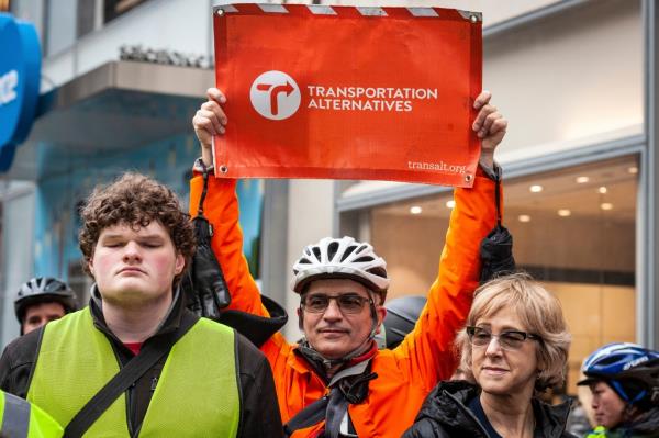 A Transportation Alternatives activist holds up a sign